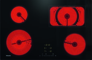 Top-down view of a black glass-ceramic electric cooktop with four red glowing round coil burners and a central digital timer display (Miele branding).