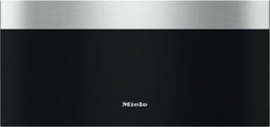 Front view of a Miele appliance with brushed stainless steel top trim and a black panel, logo centered at the bottom surface.