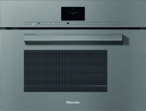 Front view of a Miele built-in oven with a small circular clock display on the control panel, slim horizontal controls, and a large vented door.