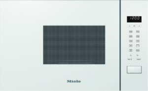 White microwave oven with a grid window, digital clock reading 12:00, and control panel on the right (Miele).