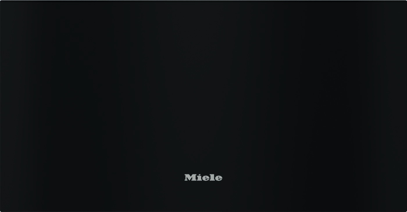 Close-up of a black appliance front with the silver Miele logo centered near the bottom of the panel.