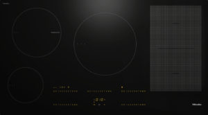 Induction cooktop with three circular cooking zones and a right-side grid panel, glowing numeric controls, Miele logo in the corner