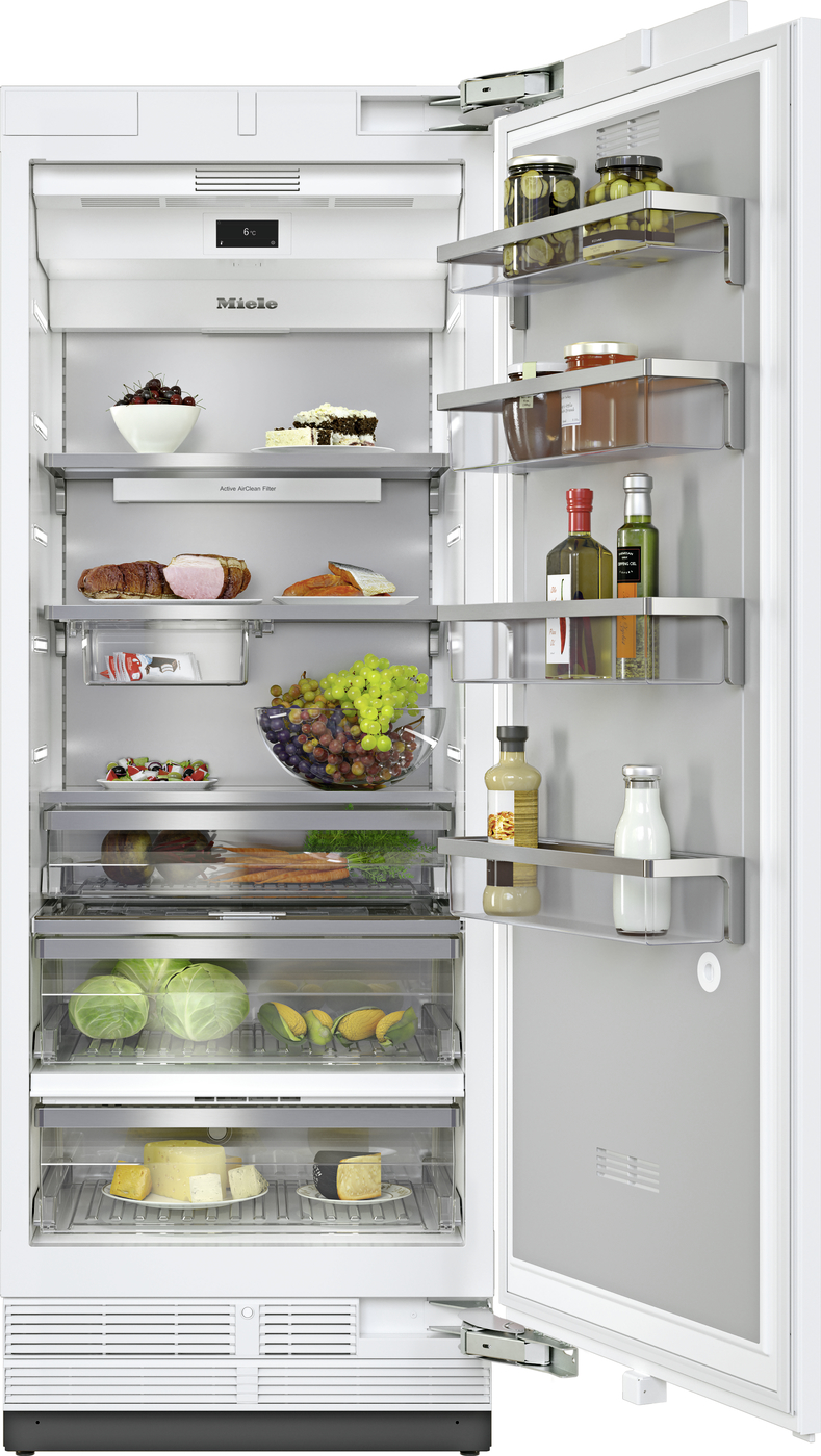 Open stainless fridge with food organized on multiple shelves: fruit, cheese, bread, vegetables, and condiments on the door.