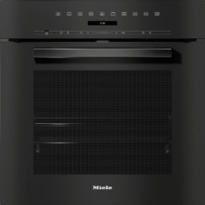 Close-up of a black Miele built-in dishwasher front with control icons row, digital display showing 12:00, and a recessed handle.