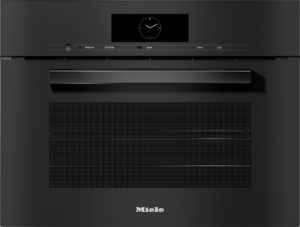 Black Miele oven front with a slim control panel, central clock display, and long metallic handle across the door