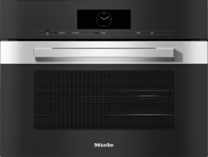 Front view of a black Miele oven with a circular clock on the control panel and a brushed stainless steel handle above the door.