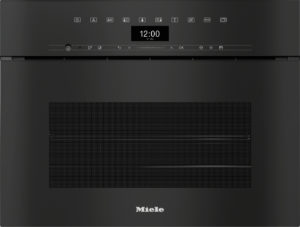 Built-in Miele oven with a digital clock reading 12:00, sleek black control panel above a large textured vent area and the Miele logo below