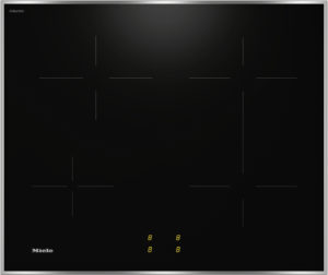 Miele induction cooktop on a black glass surface with four burner zones and a subtle glow from the control area at the bottom center.