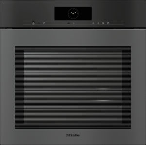 Front view of a Miele built-in oven with a circular clock on the control panel above a large glass door.