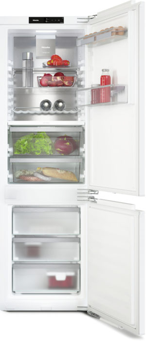 Large white refrigerator with upper fridge and bottom freezer, doors open showing shelves of fruits, vegetables, and beverages; drawers contain lettuce, tomatoes, and meats.