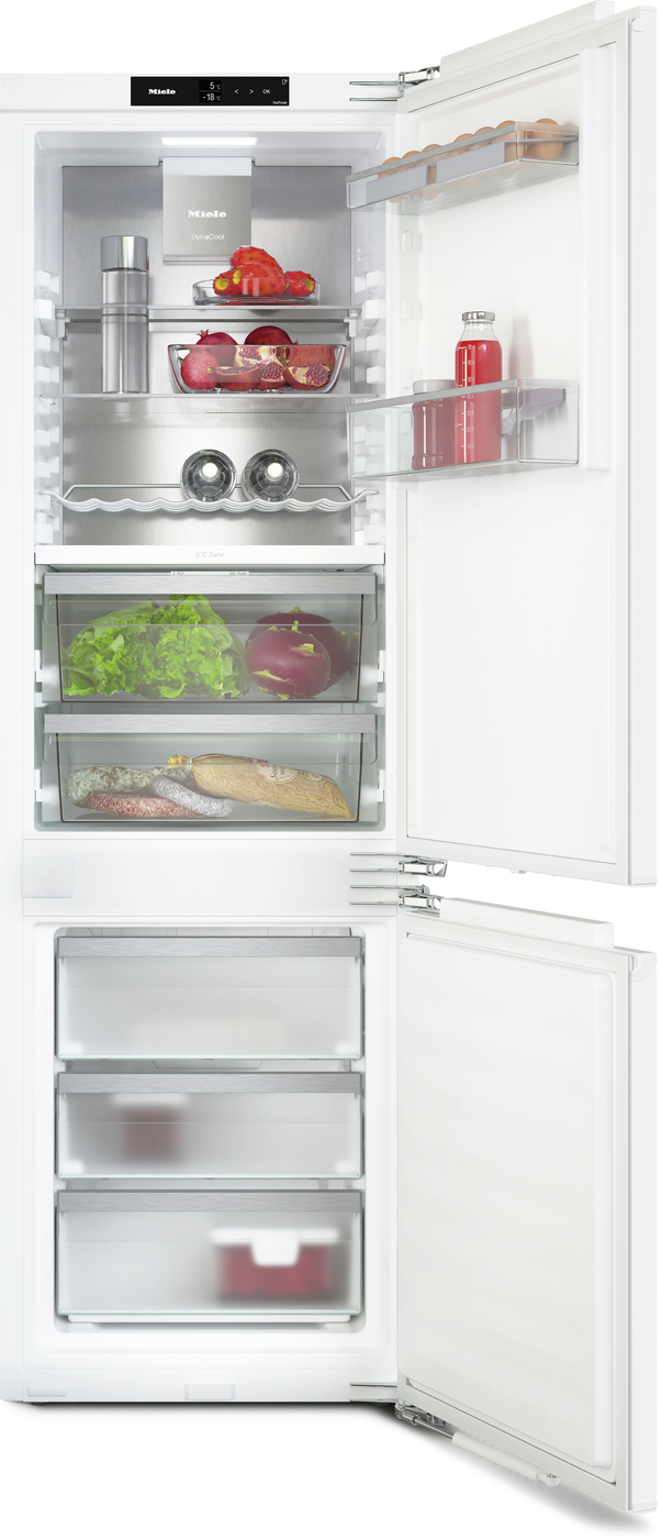 Large white refrigerator with upper fridge and bottom freezer, doors open showing shelves of fruits, vegetables, and beverages; drawers contain lettuce, tomatoes, and meats.