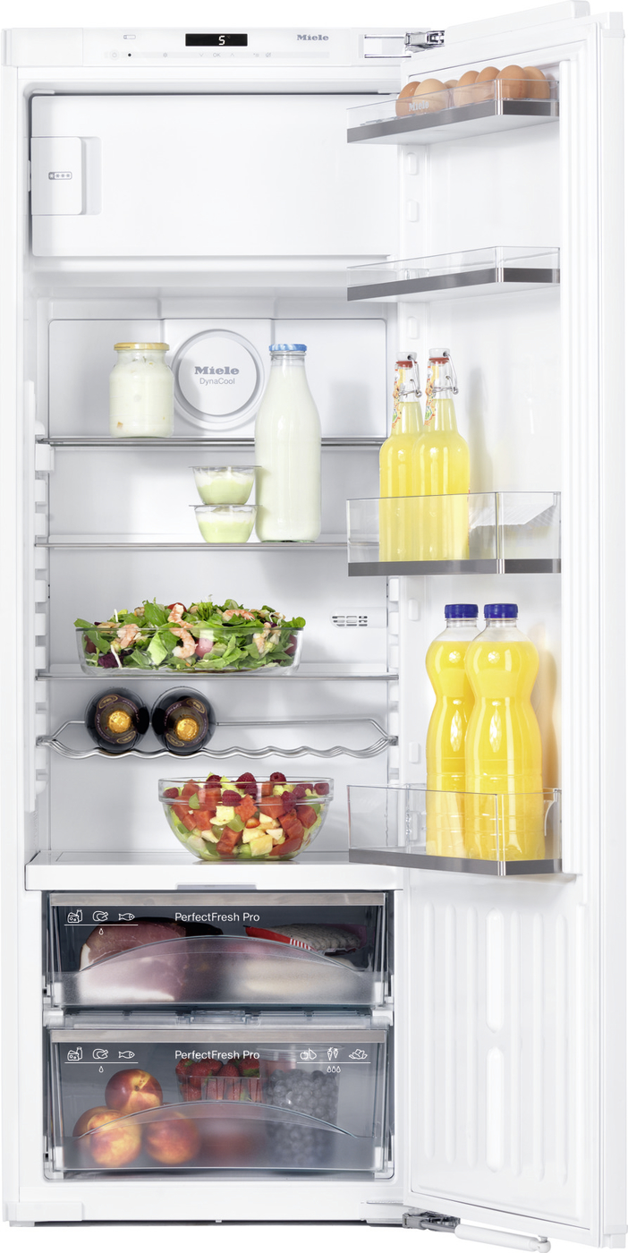 Open refrigerator showing shelves with a salad bowl, milk bottle, jars of yogurt, and orange juice bottles on the door; bottom freezer drawers visible on the lower section.