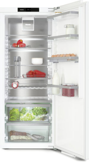 Open refrigerator showing organized shelves with produce, dairy, eggs, and jars on a white interior.