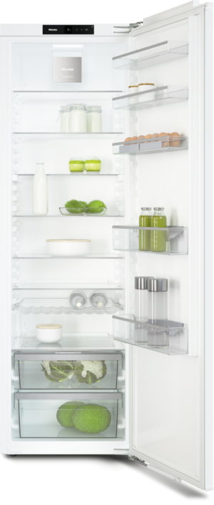 Open refrigerator showing shelves with milk, jars, eggs, vegetables, and condiments, ready for use.