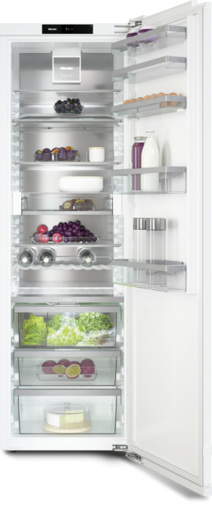 Open refrigerator with organized shelves: eggs, milk, juice, fruit, greens, and a cake at the bottom.