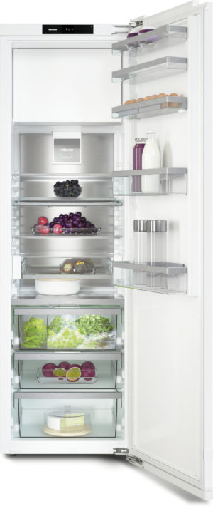Open refrigerator with multiple glass shelves filled with eggs, milk and juice, berries and grapes, greens in crisper drawers, and cheese at the bottom.