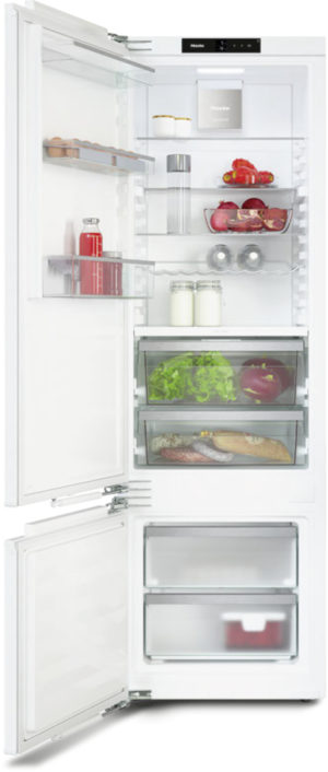 Open refrigerator with shelves of milk, juice, produce, and bread; freezer drawers at bottom.