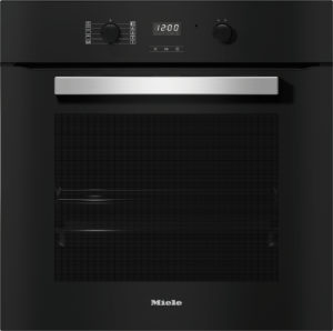 Black built-in Miele oven front with brushed metal handle and control panel featuring dials and a digital display