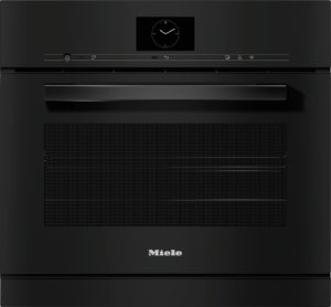 Front view of a black Miele oven with a round clock display and long handle.