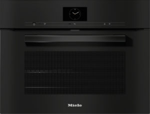 Front view of a black Miele built-in oven with a circular clock display on the control panel