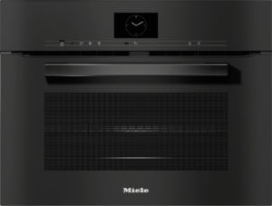 Miele built-in oven front with a central clock display, slim control bar, and wide handle on a black surface.