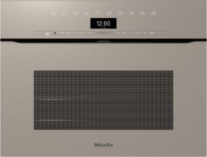 Front view of a beige Miele built-in oven with a black digital clock showing 12:00 and a slim control panel across the top with a large vent/grid in the center.