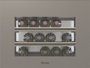 Miele built-in wine storage with three shelves holding brown wine bottles behind a perforated front.