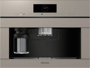 Built-in Miele coffee machine with a digital clock display and a glass carafe on the left side under a stainless panel.