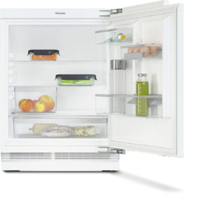Open white refrigerator with organized shelves: eggs on the door, bottle of juice, green vegetables, peaches in a bin, and cured meats at the bottom shelf