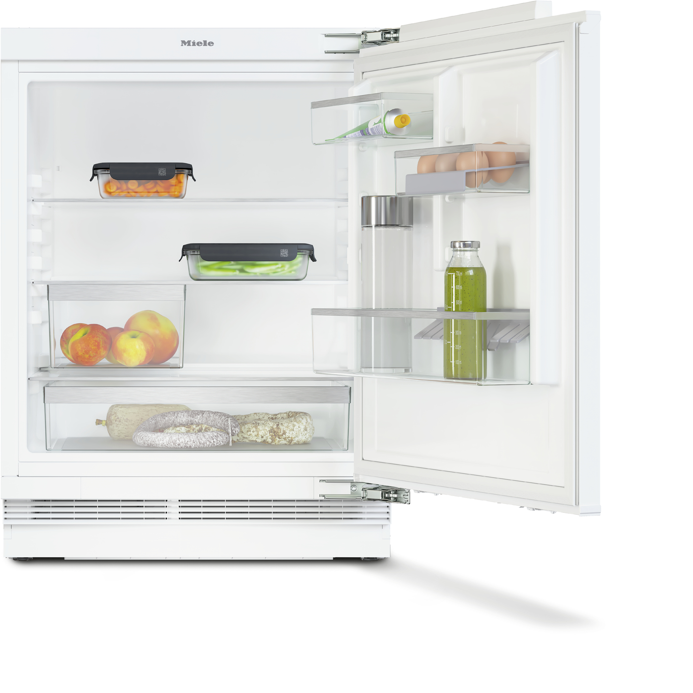 Open white refrigerator with organized shelves: eggs on the door, bottle of juice, green vegetables, peaches in a bin, and cured meats at the bottom shelf