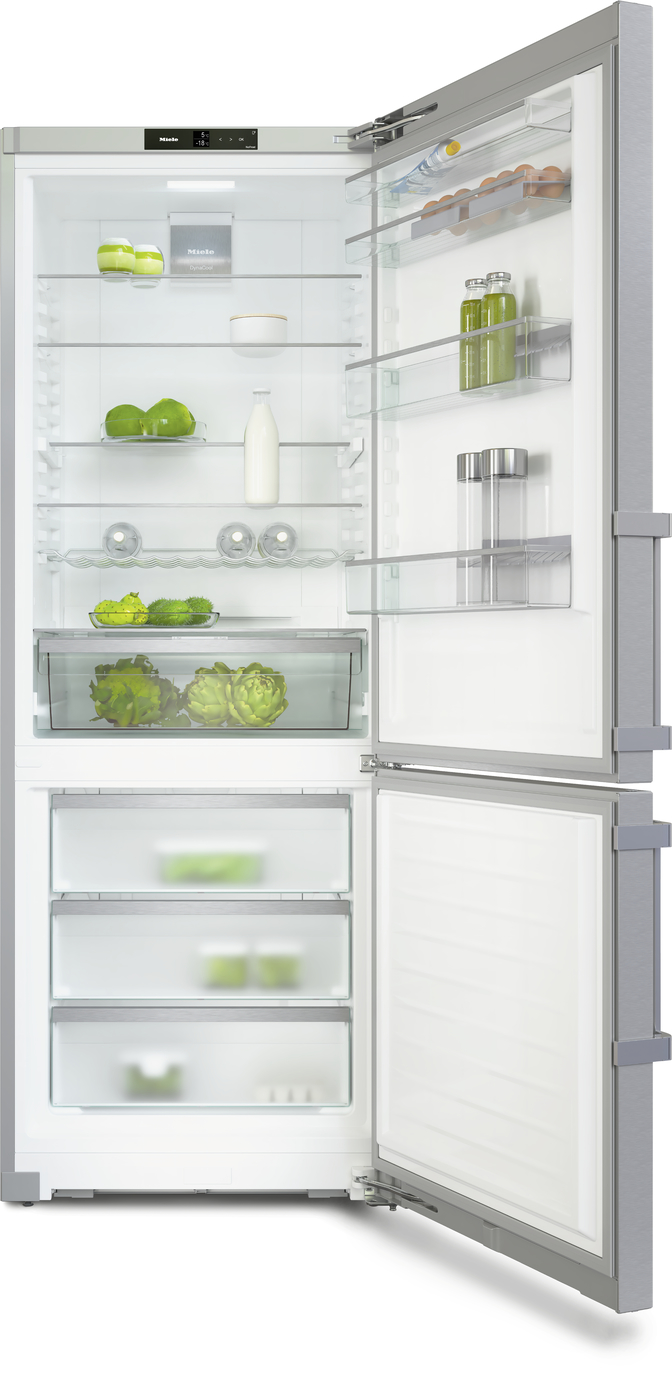 Tall side-by-side refrigerator with doors open, revealing organized shelves of milk, greens, eggs, jars, and vegetables plus a bottom freezer drawer.