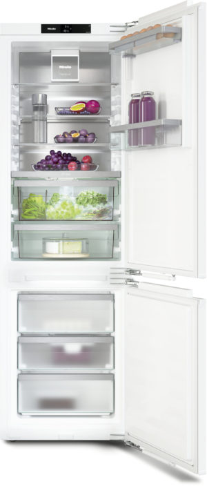 Open white refrigerator with produce drawers and shelves showing fruits, vegetables, eggs, and beverages; freezer drawers at bottom