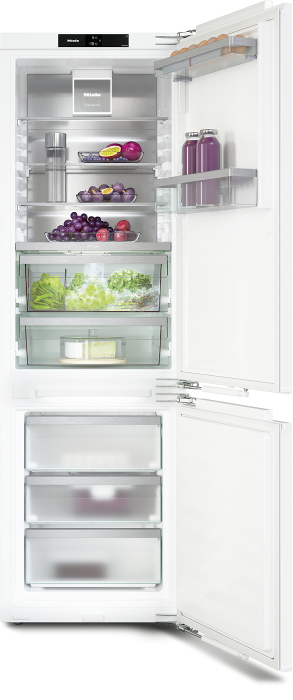 Open white refrigerator with produce drawers and shelves showing fruits, vegetables, eggs, and beverages; freezer drawers at bottom