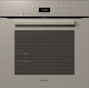 Miele built-in oven with a brushed metal finish, digital clock showing 12:00 and date, upper control panel with icons, long handle, and a large vented door window