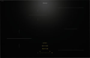 Miele induction cooktop surface with subtle line markers and a central digital timer display (black, sleek).