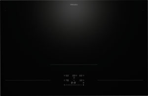 Induction cooktop from Miele, black glass surface with faint illuminated controls at center bottom and thin cooking zones on left, middle, and right (no food shown)