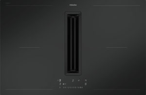 Miele induction kitchen appliance shown center-stage on a dark gradient background with a vertical, sleek black unit and control panel beneath.