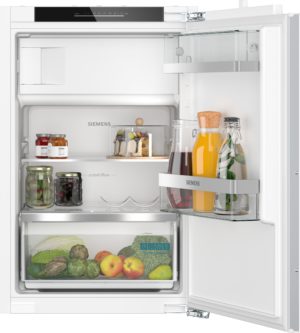 Open Siemens refrigerator showing shelves with jars, bottles and fresh fruit inside a bright white interior.