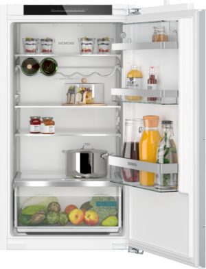 Open Siemens refrigerator with beverages and jars on door shelves, a cake on the middle shelf, and fresh produce in the bottom drawer.