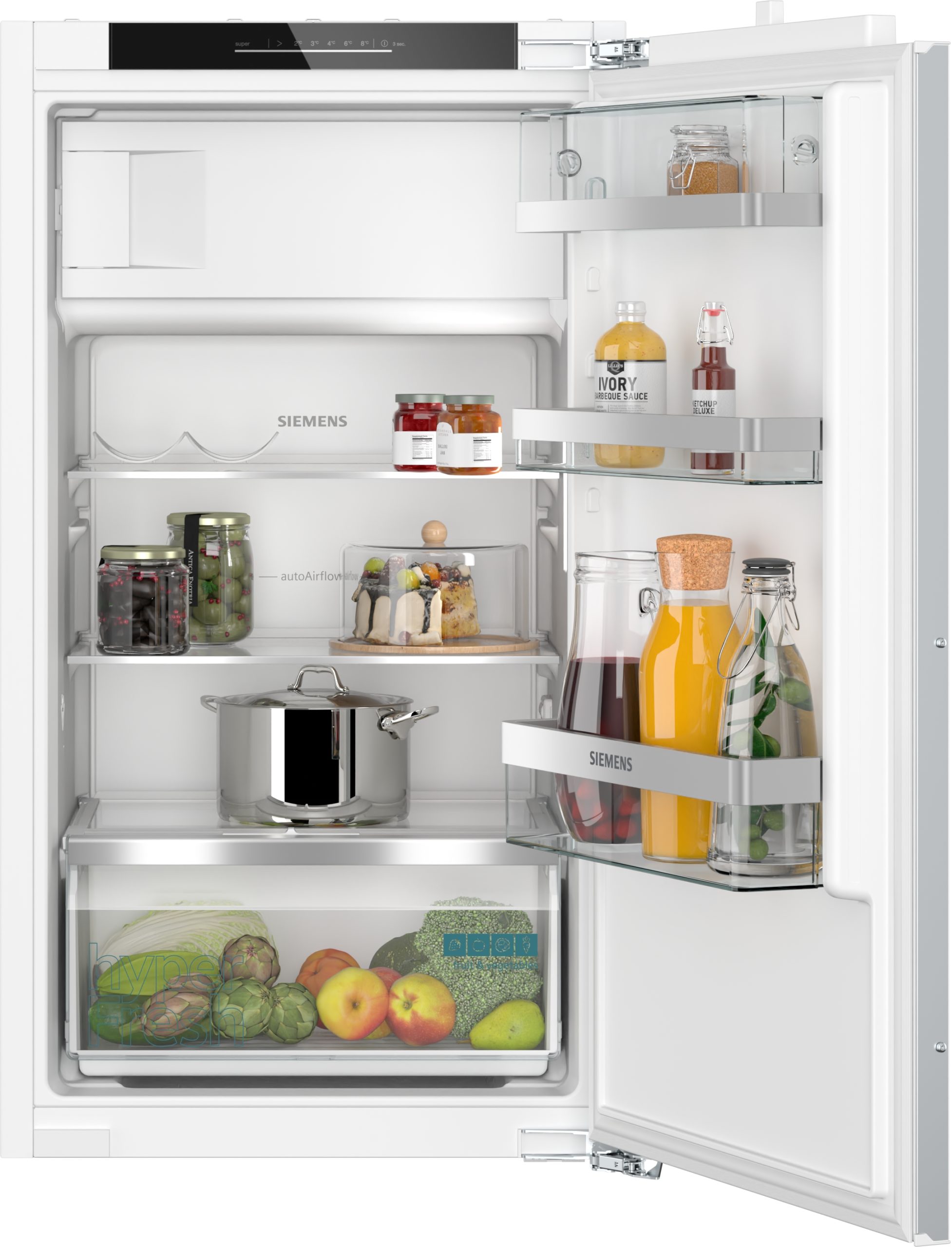 Open Siemens refrigerator showing upper shelves with jars and condiments, middle shelf with sauces, lower drawer full of fresh produce like lettuce, apples, pears, and broccoli visible at the bottom.