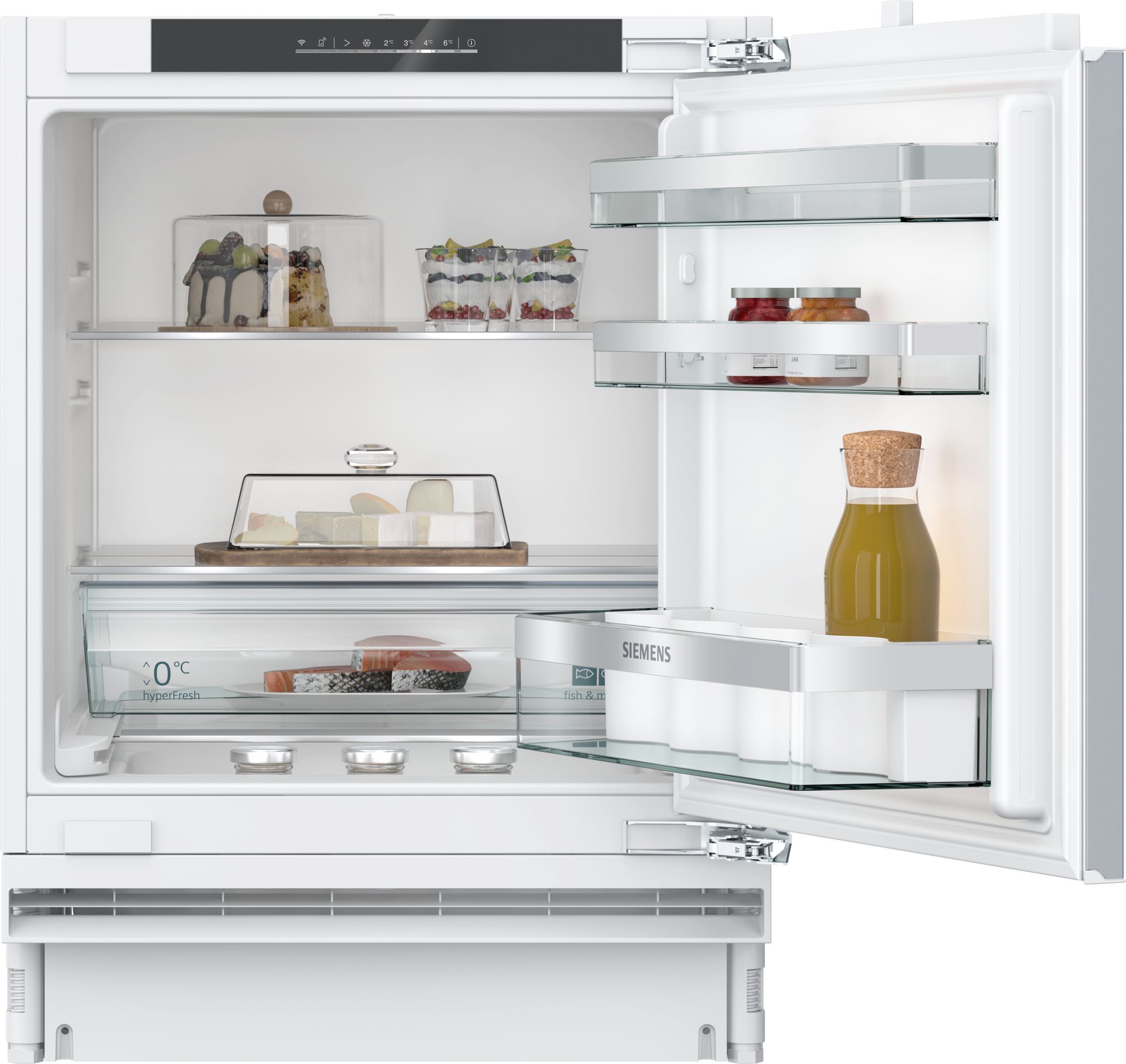 Open white refrigerator showing dessert cake and fruit cups on the left shelf, and jars of preserves on the right shelf.