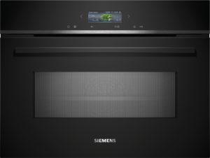 Siemens front panel of a sleek black appliance with a small display showing 'Green beans' and cooking icons, set against a dark gradient background.