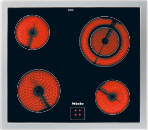 Top-down view of a four-burner electric stove with glowing red coils on a dark surface (Miele).