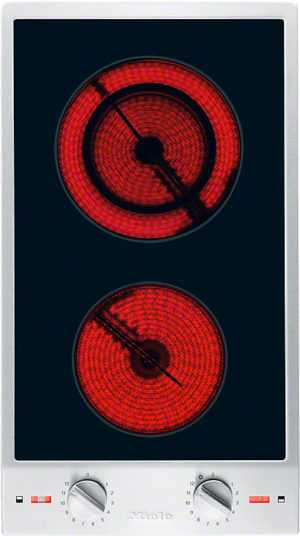 Two glowing red heating coils on a black glass electric cooktop with a silver frame and two control dials below.