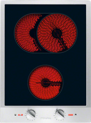 Electric stovetop with glowing red coil burners: two at the top and one at the bottom, with control knobs beneath.