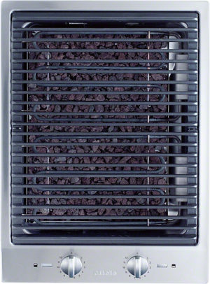 Built-in electric grill with a metal grate over dark lava rocks and two control knobs below.