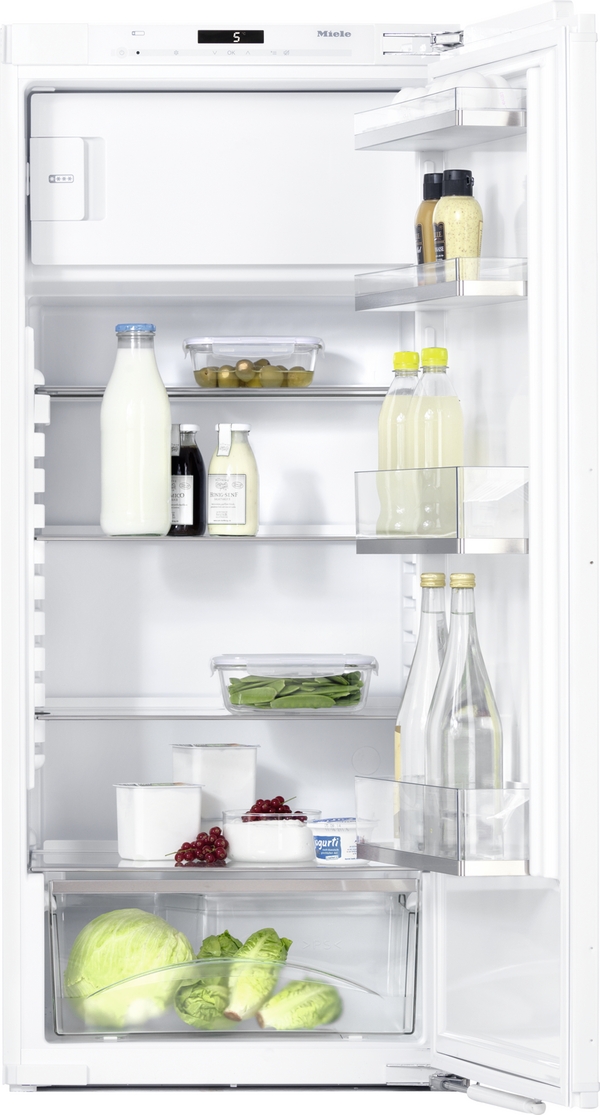 Open refrigerator displaying organized shelves: milk bottle, beverages, condiments, vegetables, and dairy products visible on glass shelves and door compartments.