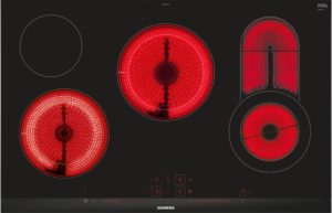 Top-down view of a black Siemens induction cooktop with red-hot circular heating zones lit and digital controls at the bottom