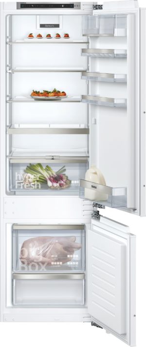 Open white Siemens refrigerator with bottom freezer, multiple shelves and crisper drawers visible.
