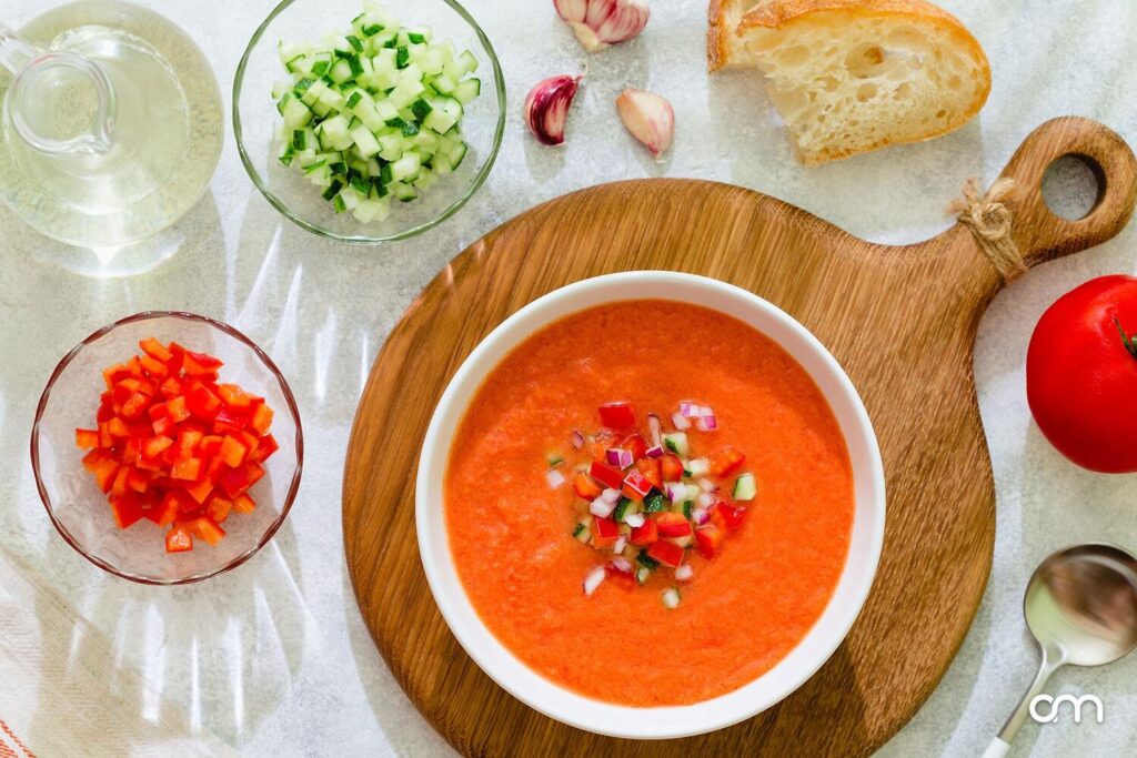 Gaspacho de tomates du marché servi frais, filet d'huile d'olive et basilic